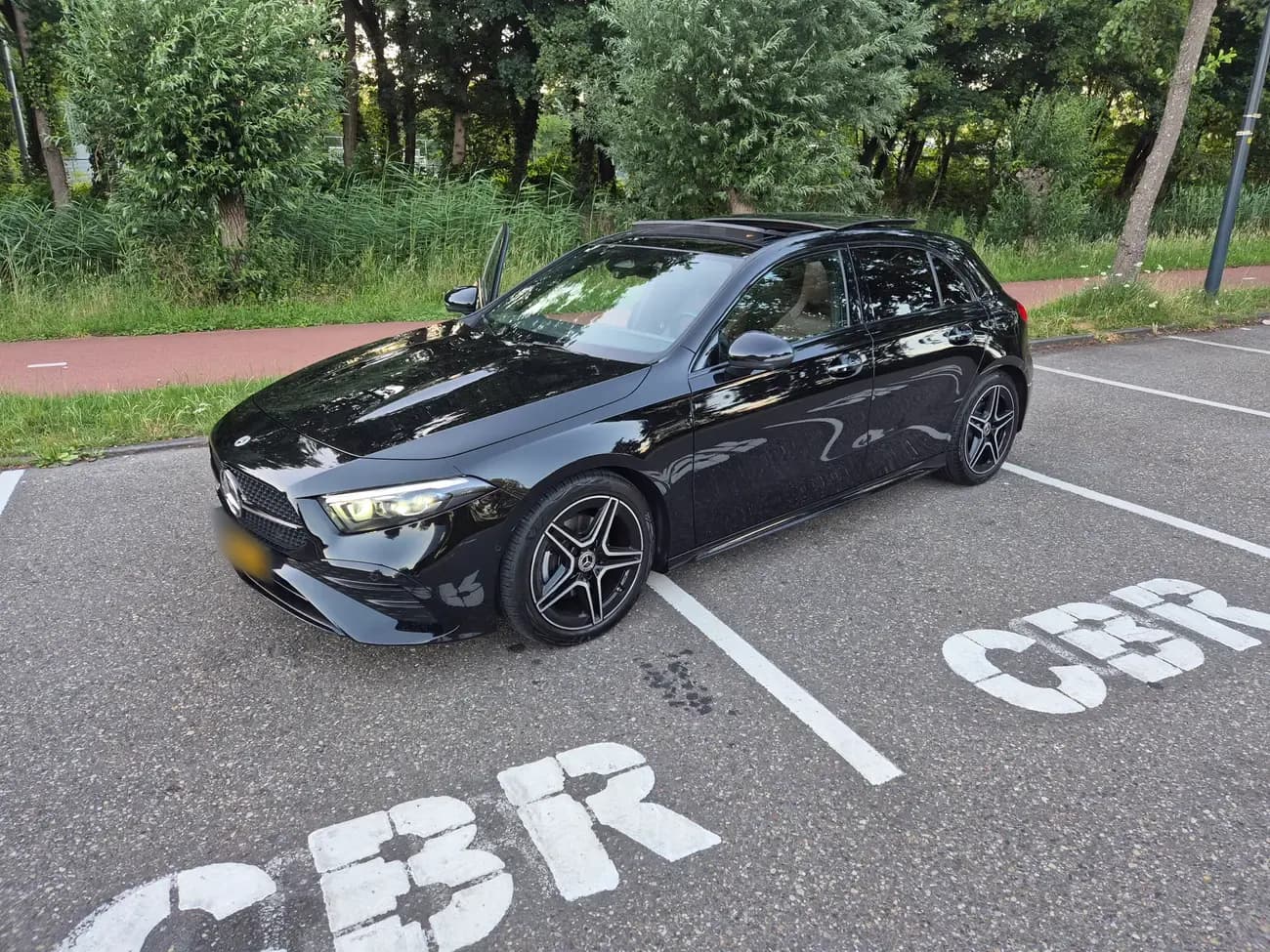 De zwarte Mercedes A180 automaat-lesauto bij het CBR-examencentrum